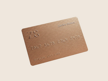 Load image into Gallery viewer, Bronze gift card with embossed text on a gray background
